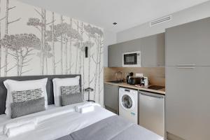 een slaapkamer met een bed en een wasmachine bij Refined air-conditioned studio in Neuilly in Neuilly-sur-Seine