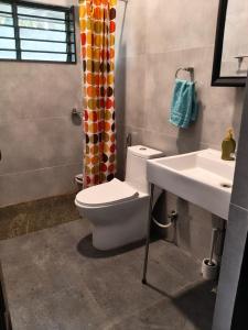 een badkamer met toilet en wastafel bij Under the Tamarind in Bangalore