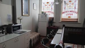a kitchen with a refrigerator and a table and chairs at The Eastern Hotel Accommodation in Ballarat