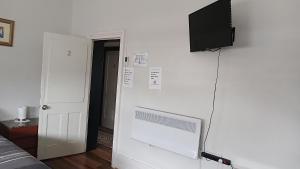 a room with a tv on a white wall at The Eastern Hotel Accommodation in Ballarat