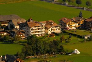 un gruppo di case in un campo verde di Hotel Reipertingerhof a Brunico