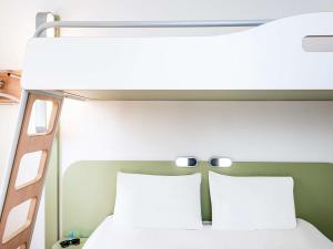 a bedroom with a white bed and white walls at ibis budget Brugge Centrum Station in Bruges