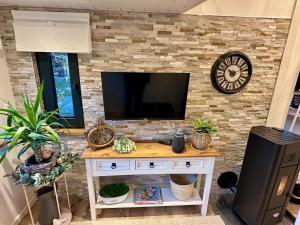 a living room with a tv on a brick wall at Sunset Tiny House GbR in Neuendorf