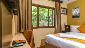 una stanza d'albergo con un letto e una finestra di Hollywood Hotel Puerto Princesa a Città di Puerto Princesa