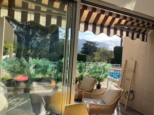 a patio with a window with chairs and a patio umbrella at Lou soulèu in Cassis