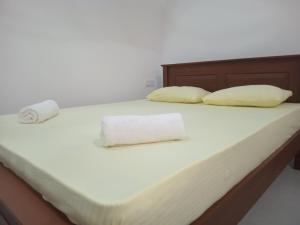 een bed met witte lakens en kussens erop bij Mihinsa Guest in Kosgoda