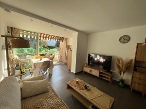 a living room with a couch and a tv and a table at Lou soulèu in Cassis
