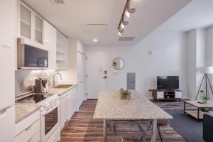 una cucina con mobili bianchi e un tavolo di CozySuites Sky Central #17 a Cincinnati Altre 15 foto