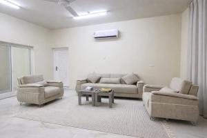 ein Wohnzimmer mit zwei Sofas und einem Tisch in der Unterkunft Remal Camp in Al Raka