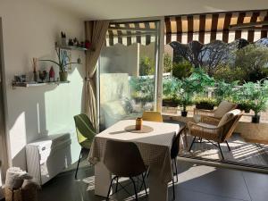 a room with a table and chairs and a patio at Lou soulèu in Cassis