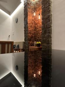een kamer met een stenen muur en een trap met verlichting bij Asramom Home in Kollam