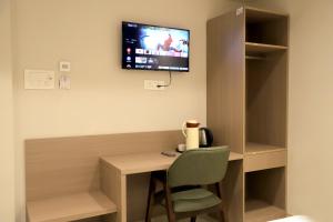 a desk with a chair and a tv on a wall at Hotel Vivaan - Walk to Banke Bihari Temple in Vrindāvan