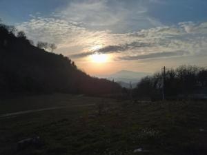a sunset on a hill with the sun setting at Apartment in a farmhouse with 2 swimming pools in Cagli +33 photos