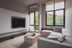 a living room with a couch and a flat screen tv at Your Luxury Villa in the South of Jakarta in Samporo