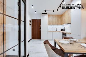 a kitchen and dining room with a wooden table and chairs at Klementyna in Bystra +2 photos