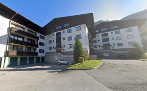 a building with a car parked in a parking lot at NĀVA PLACE Premium Alpine Apartment in Kaprun - Private Sauna, Peaceful Location, Near Glacier & WIFI in Kaprun