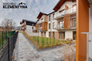 an apartment building with a fence next to a sidewalk at Klementyna in Bystra