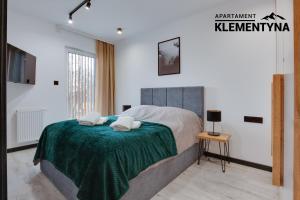 a bedroom with a bed with a green blanket at Klementyna in Bystra