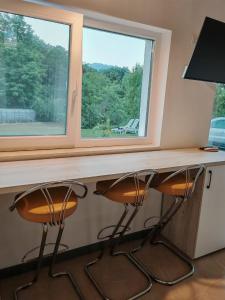 een bureau met 2 stoelen voor een raam bij Epic Glamping in Călimăneşti