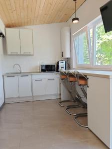 een keuken met witte kasten en een aanrechtblad bij Epic Glamping in Călimăneşti