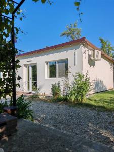 een klein wit huis met een tuin bij Epic Glamping in Călimăneşti