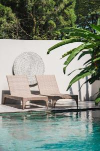 two chairs sitting next to a swimming pool at Your Luxury Villa in the South of Jakarta in Samporo