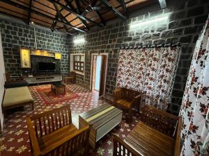 a living room with wooden benches and a brick wall at Honeycomb Abode in Salem