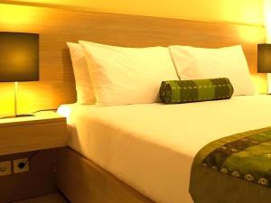 a hotel room with a large bed with white pillows at Eazy Suite Legian in Seminyak +75 photos