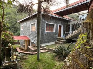 a stone house with a red window and stairs to it at Honeycomb Abode in Salem
