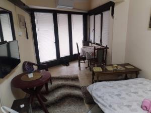 a living room with a bed and a table and chairs at TREF 1 in Soko Banja +2 photos