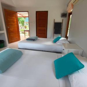 three beds in a room with blue pillows on them at Phalarn Inn Resort in Mae Nam