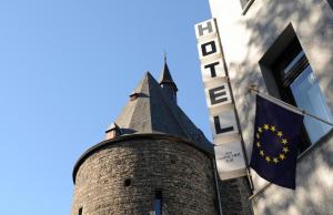 ein Gebäude mit einem Turm mit einer Flagge darauf in der Unterkunft Hotel am Marschiertor in Aachen