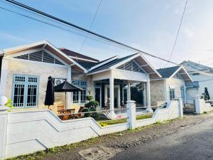 a white house with a porch with a table at Kalandra Living in Yogyakarta
