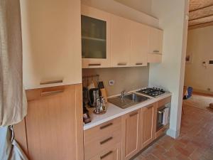 een kleine keuken met een spoelbak en een fornuis bij Modern holiday home in Foligno - Loc with pool in Case Vecchie