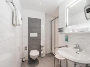 ein weißes Badezimmer mit Toilette und Waschbecken in der Unterkunft Hotel am Marschiertor in Aachen + 44 Fotos
