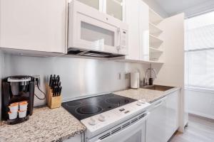 una cucina con mobili bianchi e un forno a piano cottura di CozySuites Sky Central #6 a Cincinnati
