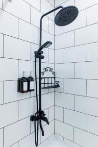 een douche in een badkamer met witte tegels bij Lavender H in Khujand