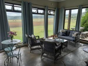 a living room with a couch and chairs and a table at Springwater Cottages in Ficksburg