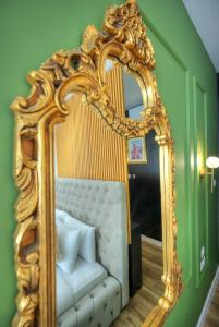 einen goldenen Spiegel mit einem Bett im Zimmer in der Unterkunft The Loft in Sliema