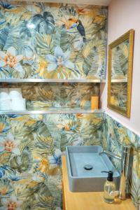 ein Badezimmer mit einem Waschbecken und einer Blumentapete in der Unterkunft The Loft in Sliema + 1 Foto