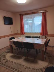 una sala da pranzo con tavolo e sedie in legno di Timi Kulcsosház a Lăzarea