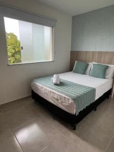 una camera da letto con un letto grande con una finestra di Conforto e Aconchego em Imbassaí/BA a Imbassai