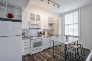 a kitchen with white cabinets and a table at CozySuites Sky Central #22 in Cincinnati +16 photos