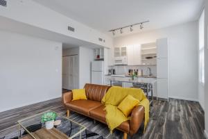 un soggiorno con un divano marrone e una cucina di CozySuites Sky Central #21 a Cincinnati