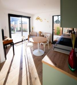 een keuken en woonkamer met een tafel en stoelen bij Kercabellec in Mesquer