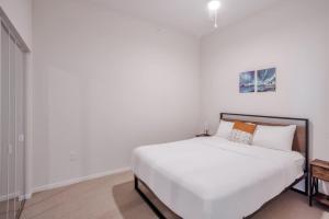 a bedroom with a large white bed with white sheets at CozySuites Sky Central #23 in Cincinnati