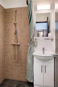 a bathroom with a shower and a sink at Dancenter Hotel Jomfru Ane in Aalborg