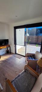 een woonkamer met een bank en een grote glazen schuifdeur bij Kercabellec in Mesquer