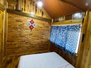 a small room with a bed in a wooden cabin at Friendly Homestay & Authentic Trekking Tours in Sapa