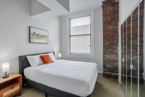 een witte slaapkamer met een bed en een raam bij CozySuites Sky Central #4 in Cincinnati